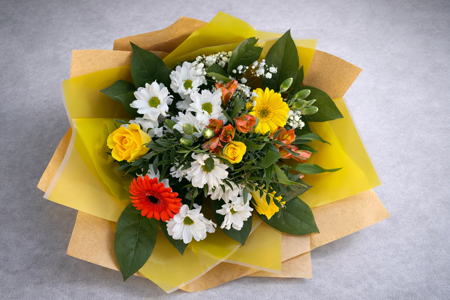 Bouquet of flowers with yellow, white, and red flowers on a gray background