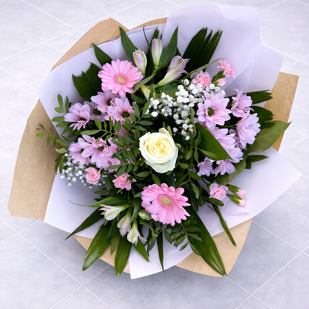 Bouquet of flowers wrapped in brown paper on a light gray surface