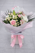 Bouquet of flowers with pink ribbon on a light gray background